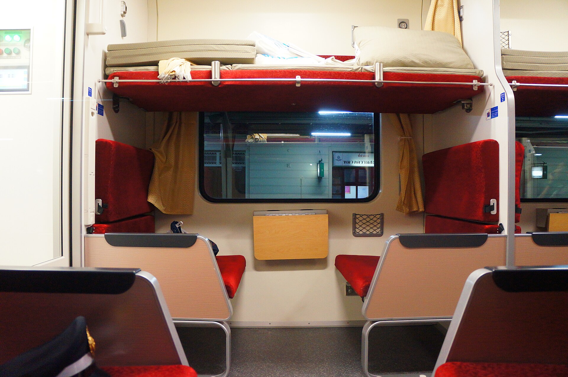 Made-up berths in a second class sleeper carriage on a State Railway of Thailand train, with curtained bunks along both sides of the aisle.