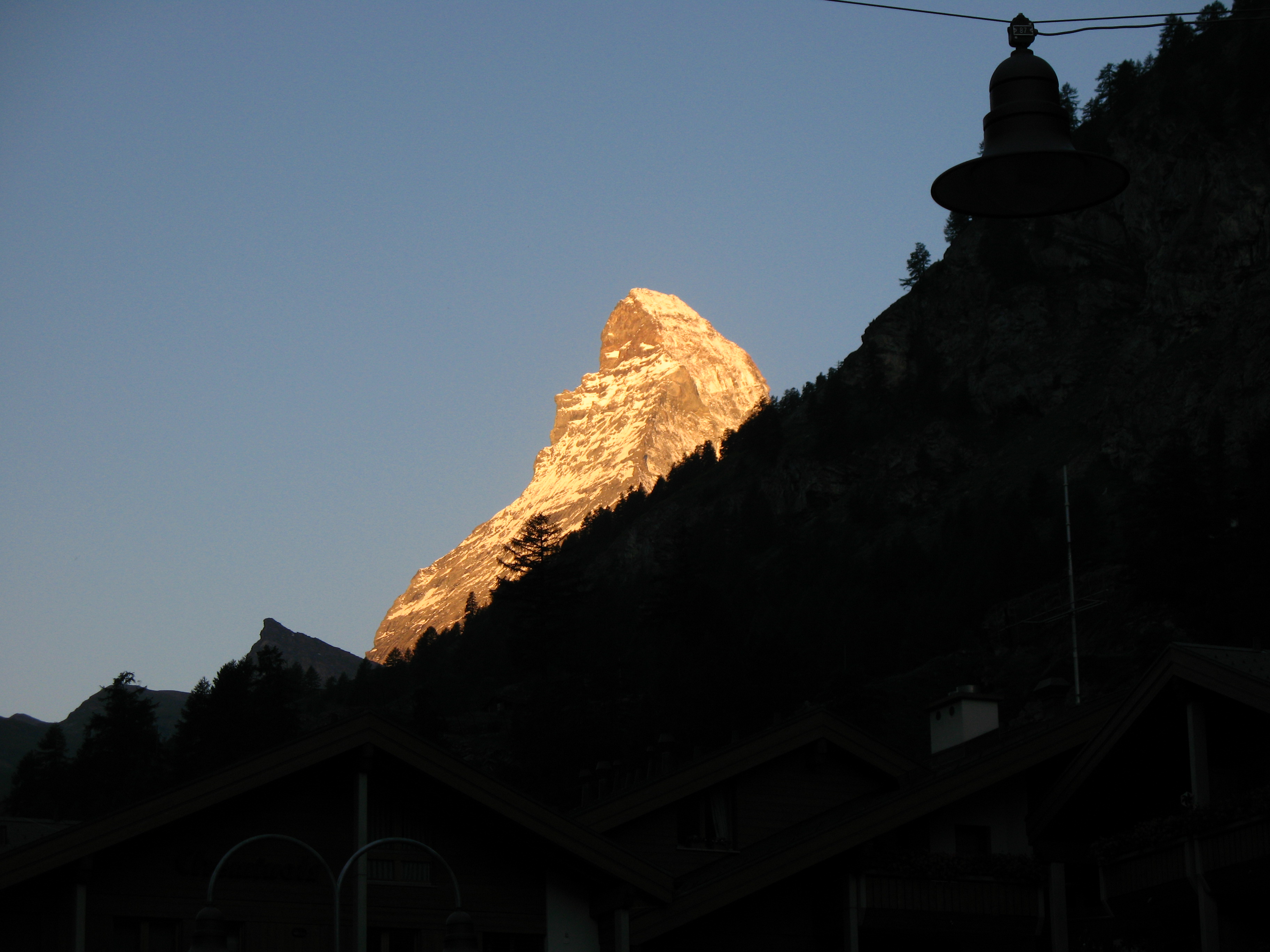 The Matterhorn seen from Zermatt's main street, its pyramid peak rising above the rooftops of the car-free village.