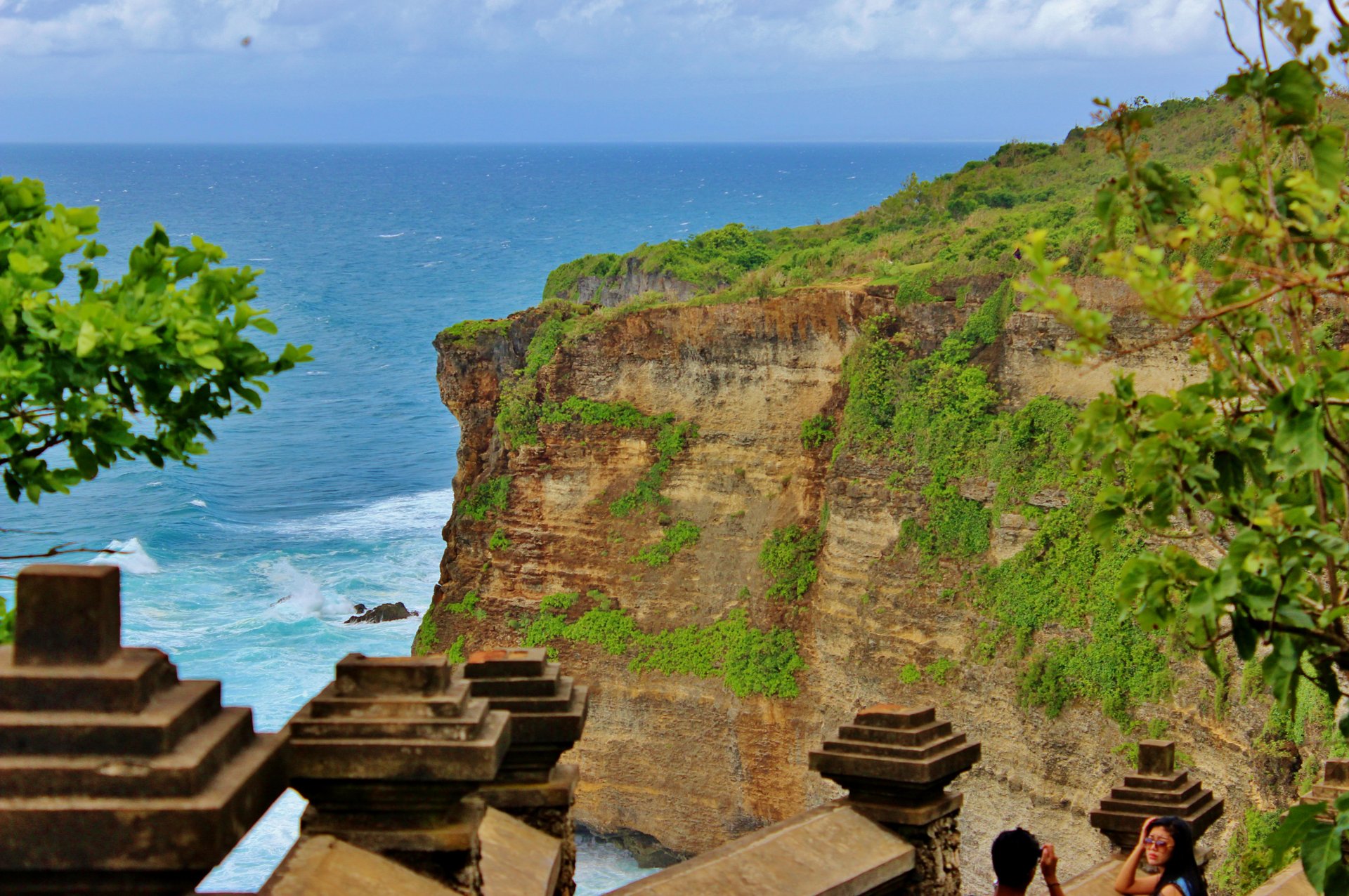 Pura Luhur Uluwatu temple perched on a limestone cliff above the Indian Ocean in south Bali, with sea cliffs stretching along the coastline.