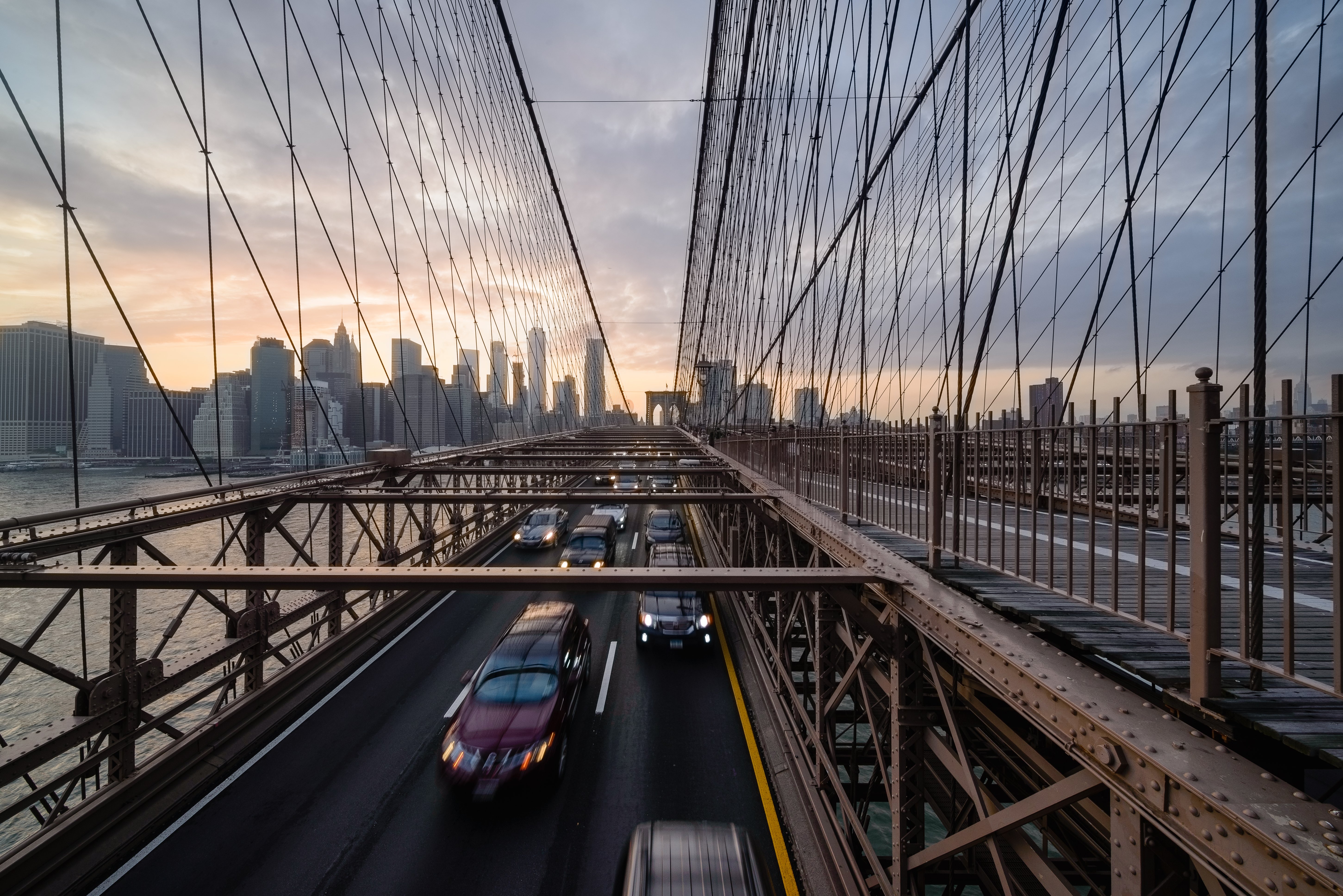 The Brooklyn Bridge, seen from the Manhattan side, with its stone towers and web of cables.