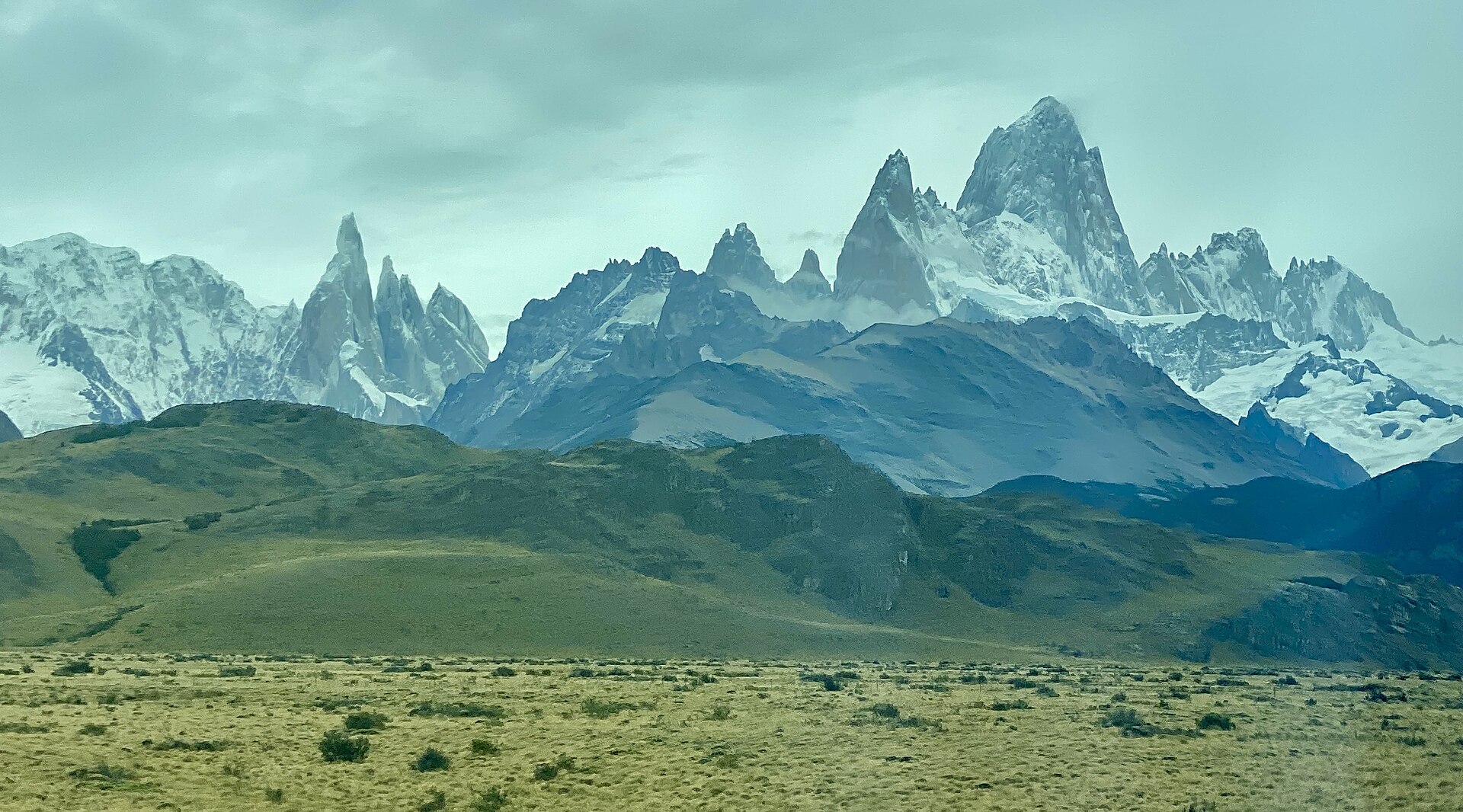 The granite spires of Monte Fitz Roy and Cerro Torre above the valley at El Chaltén, Argentine Patagonia, with cloud streaming off the summits.