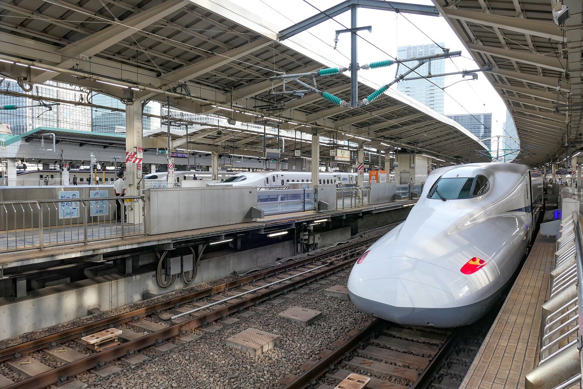 An N700 series Shinkansen train standing at a Tokaido Shinkansen platform at Tokyo Station, its long white nose angled towards the camera.