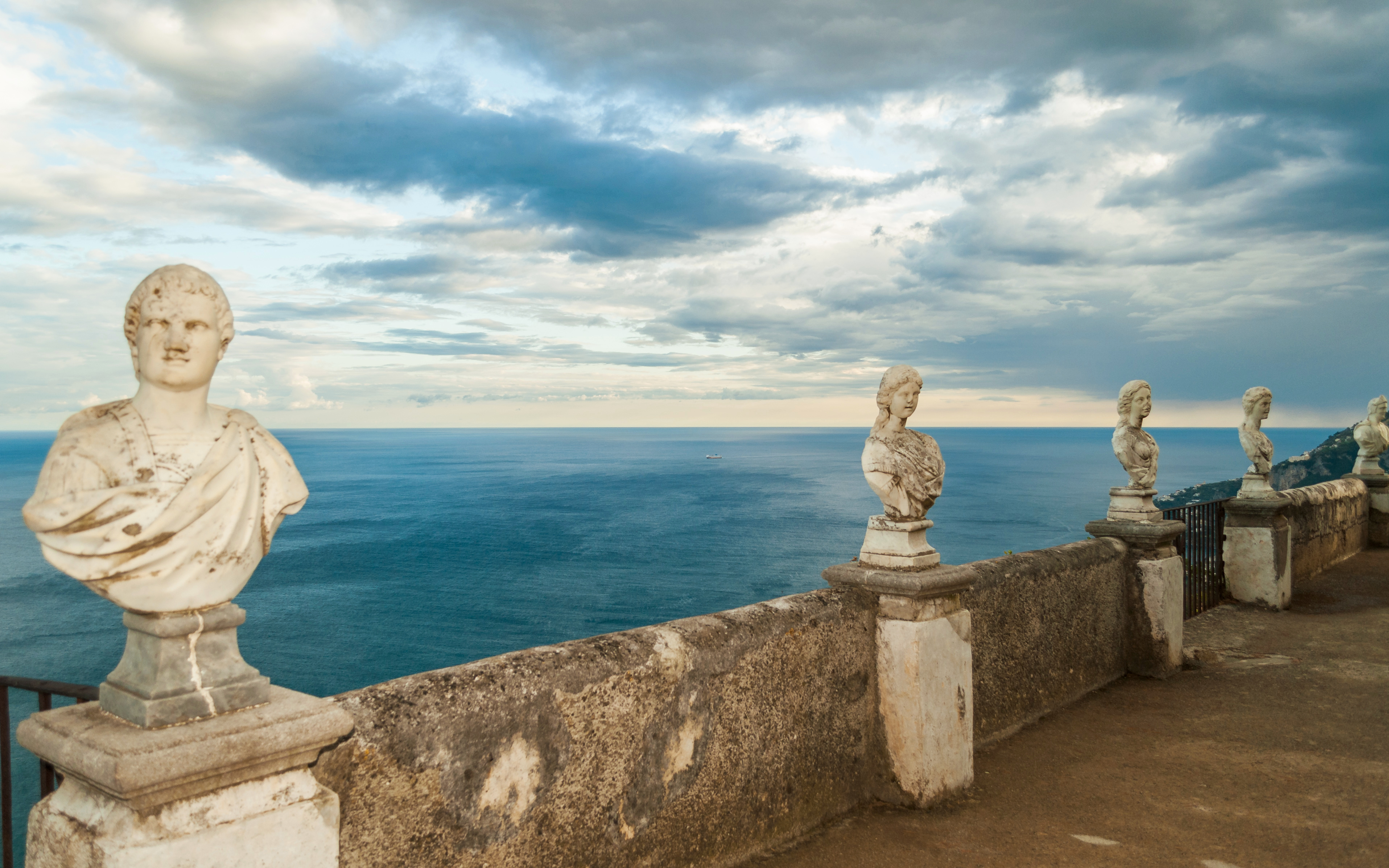 Villa Cimbrone's Terrace of Infinity in Ravello, a balustrade lined with classical busts overlooking the Amalfi Coast and the sea far below.