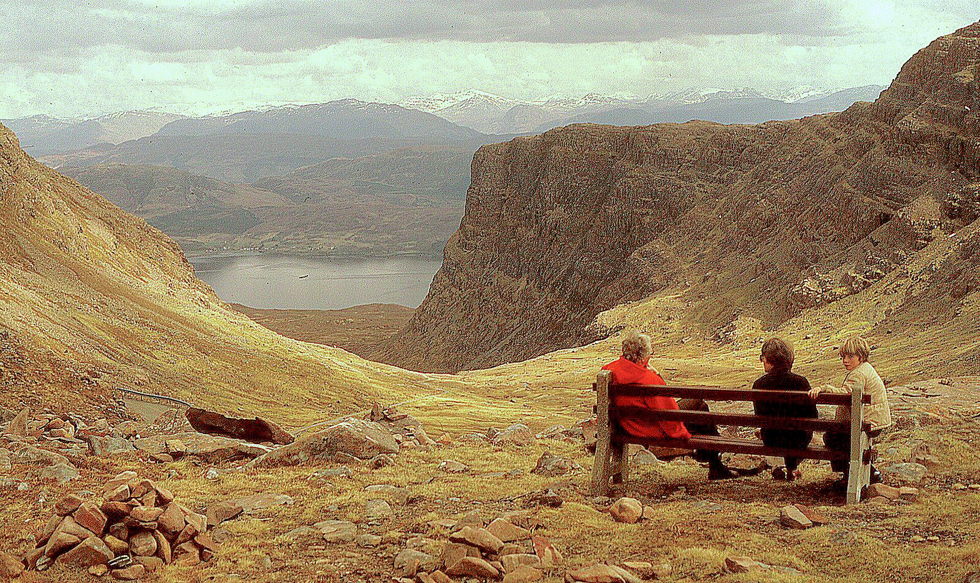 The single-track hairpin bends of the Bealach na Ba mountain road climbing through bare rock in Wester Ross, Scotland, under grey cloud.